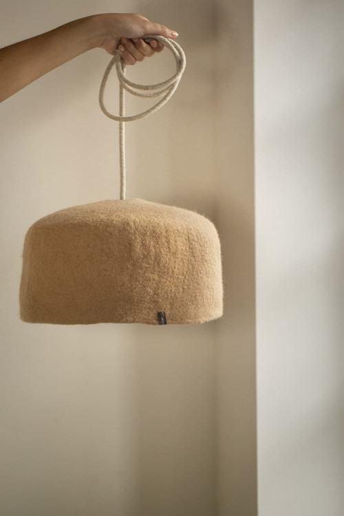 Suspension d'un luminaire Yourte nude pour apporter un aspect chaleureux.