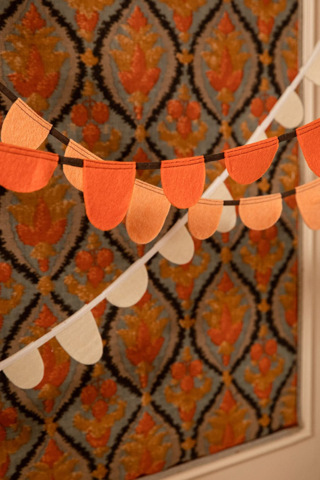 two white and mustard felt garlands placed above a crib