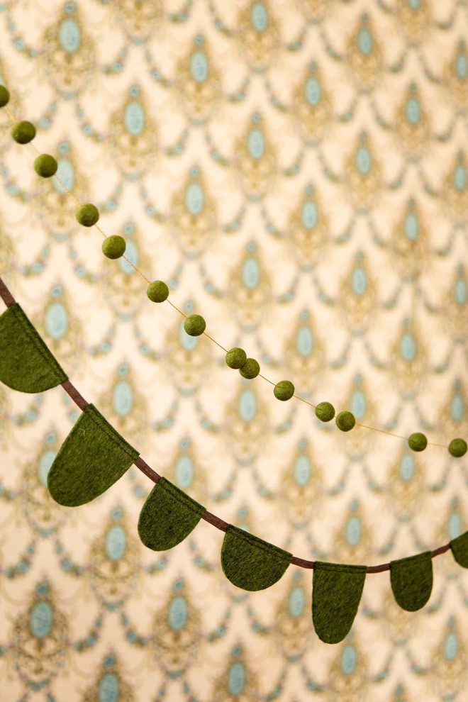 two white and mustard felt garlands placed above a crib