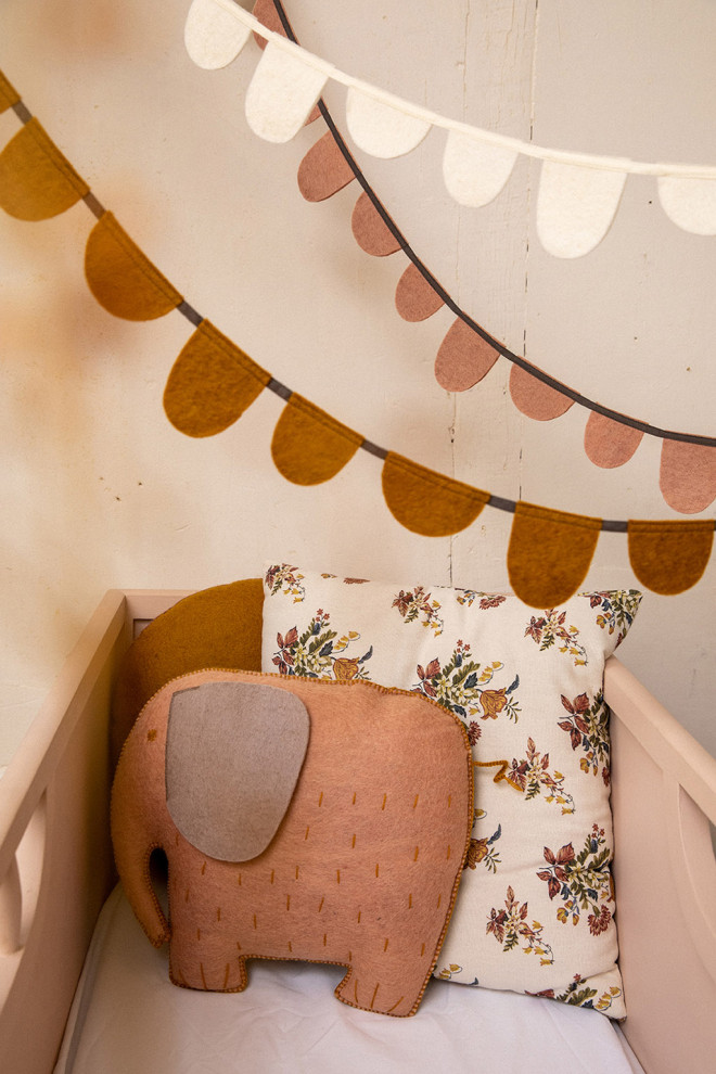 two white and mustard felt garlands placed above a crib