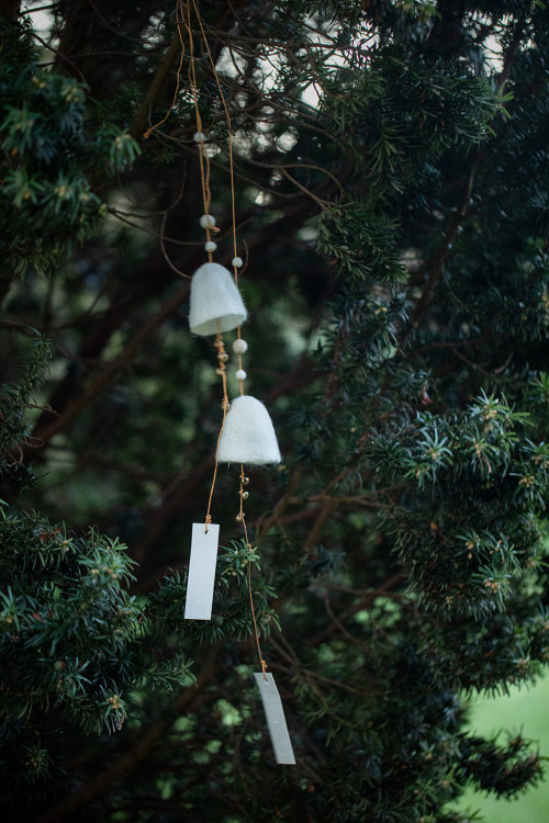 two felted wool bells are carried by the wind in a light way