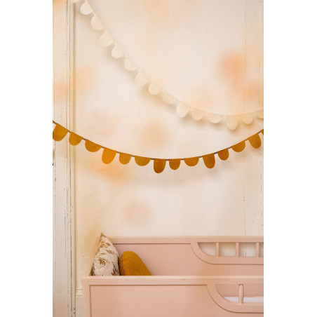 two white and mustard felt garlands placed above a crib