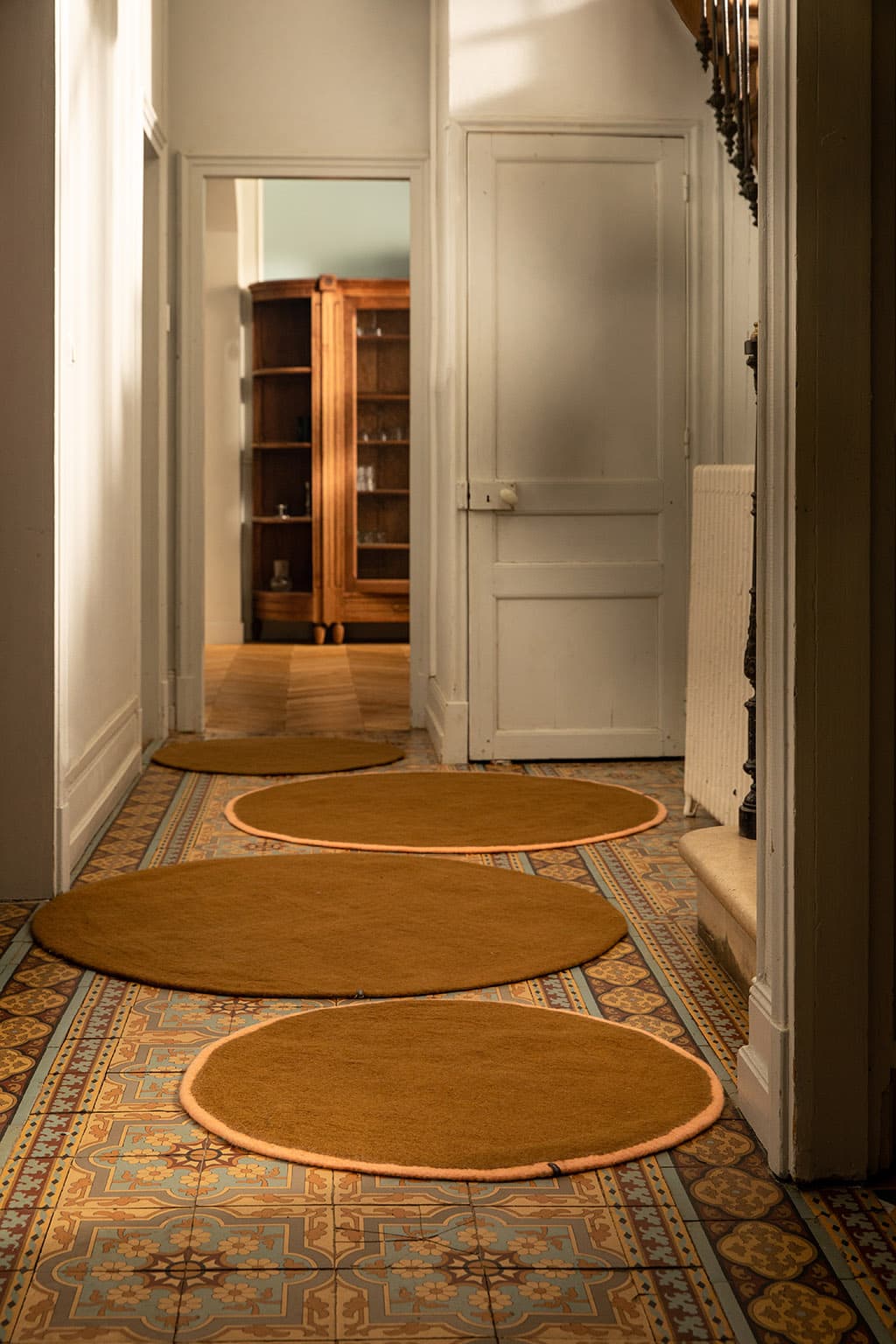 4 tapis ronds en laine marron dans une entrée