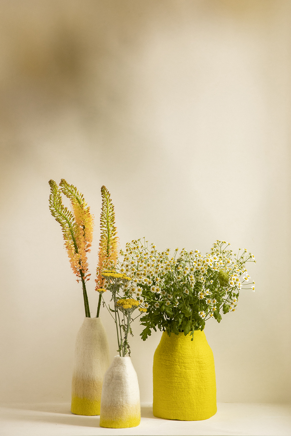 Trio de vases jaunes en laine bouillie pour orner une table à manger