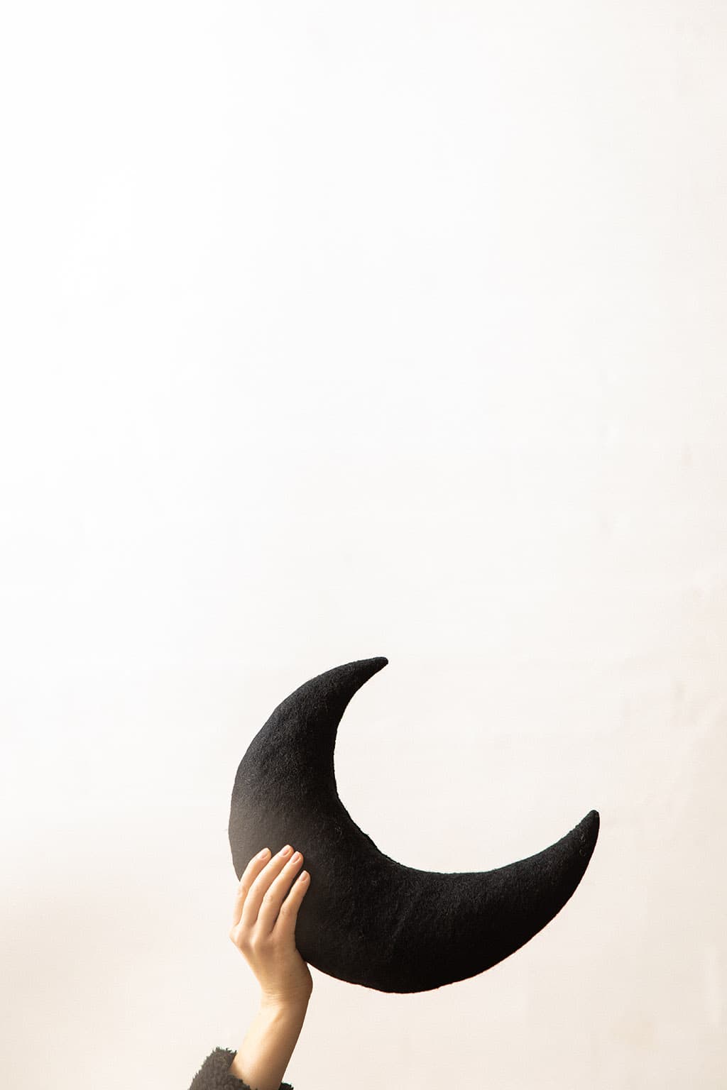 Coussin lune noir en feutre de laine