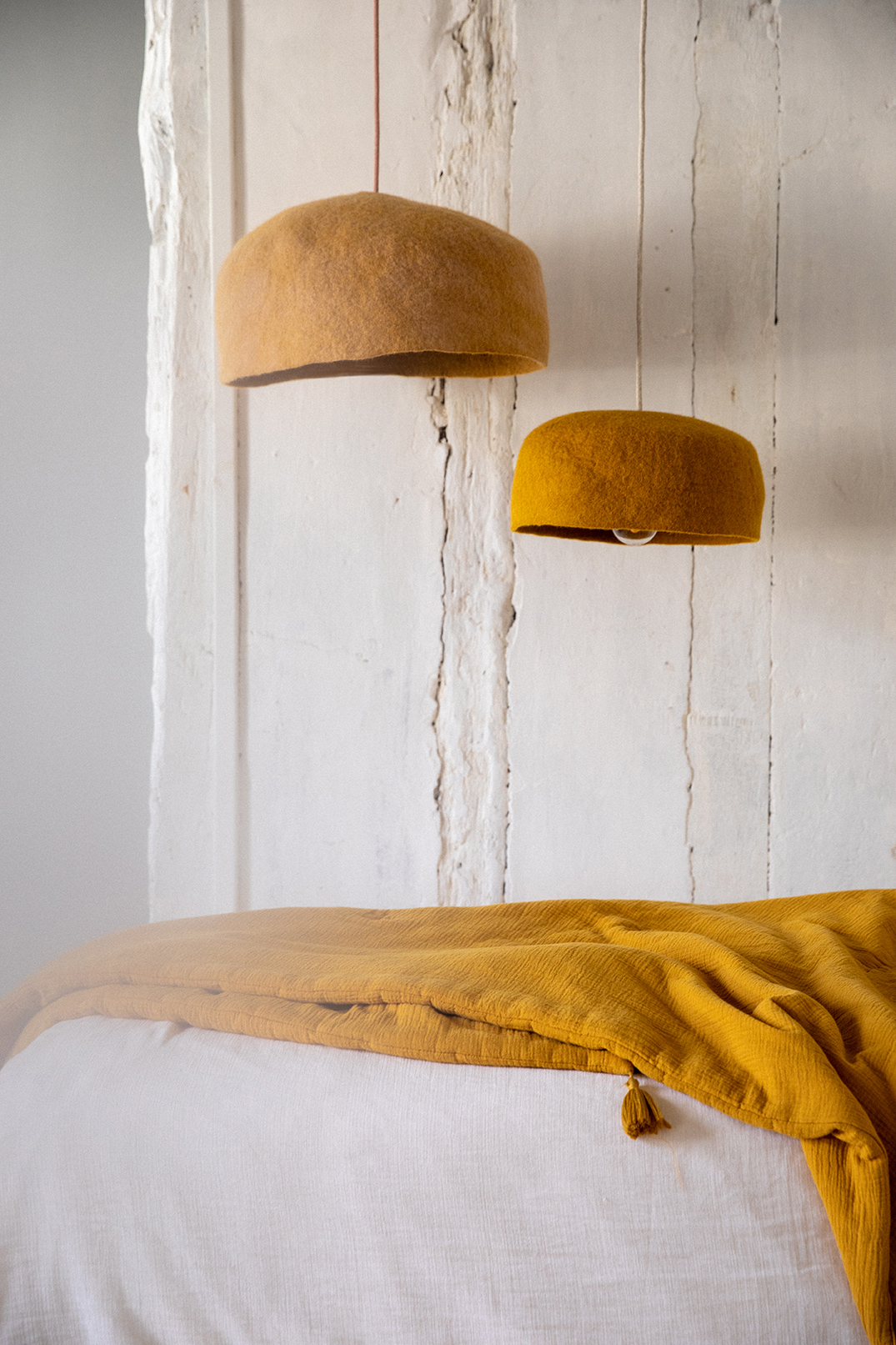 Duo de suspensions et dessus de lit ocre dans la chambre