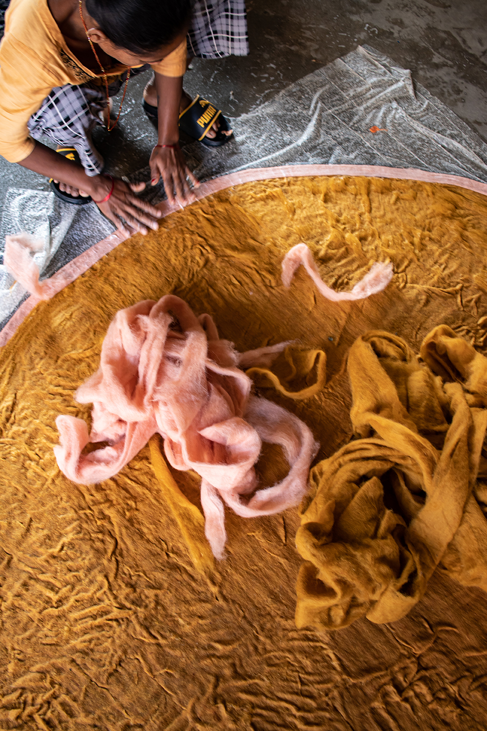 Nepalese craftswoman making a round felted wool carpet